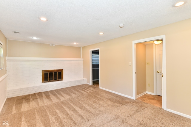 524 Concord Ct, Fishers, IN 46038 - unfurnished living room with carpet, recessed lighting, a brick fireplace, and a textured ceiling