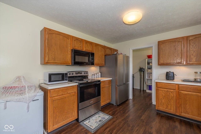 3624 Newberry Rd, Plainfield, IN 46168 - kitchen with stainless steel appliances, light countertops, dark wood-style flooring, a textured ceiling, and brown cabinetry