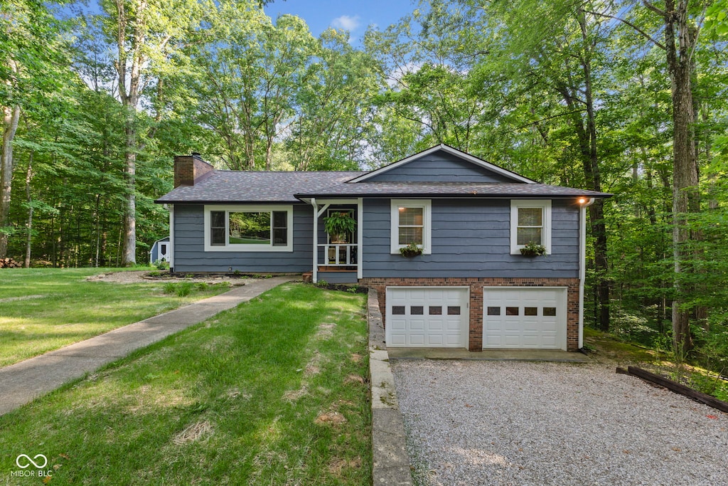 4179 E Rembrandt Dr, Martinsville, IN 46151 - view of front of property featuring driveway, a garage, a chimney, a front yard, and a shingled roof