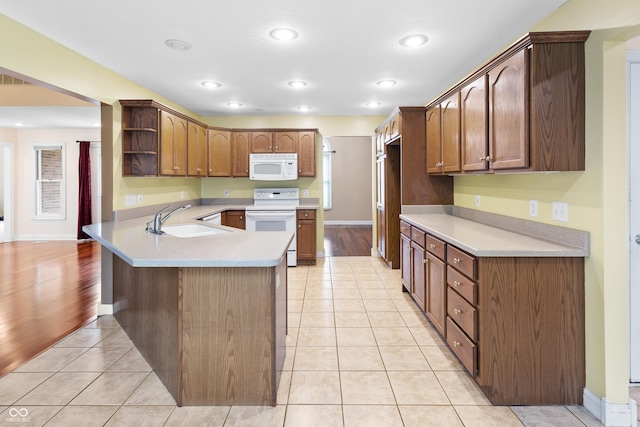 3244 Skyview Ct, Columbus, IN 47203 - kitchen with white appliances, a peninsula, open shelves, light tile patterned floors, and light countertops