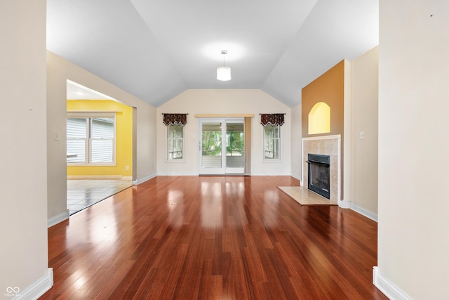 3244 Skyview Ct, Columbus, IN 47203 - unfurnished living room featuring a tile fireplace, wood finished floors, plenty of natural light, and vaulted ceiling