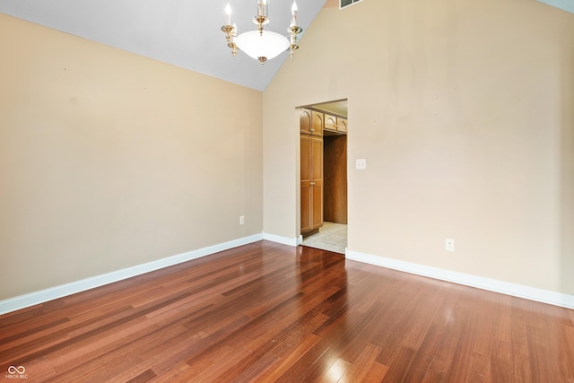 3244 Skyview Ct, Columbus, IN 47203 - unfurnished room featuring a chandelier, high vaulted ceiling, and dark wood finished floors