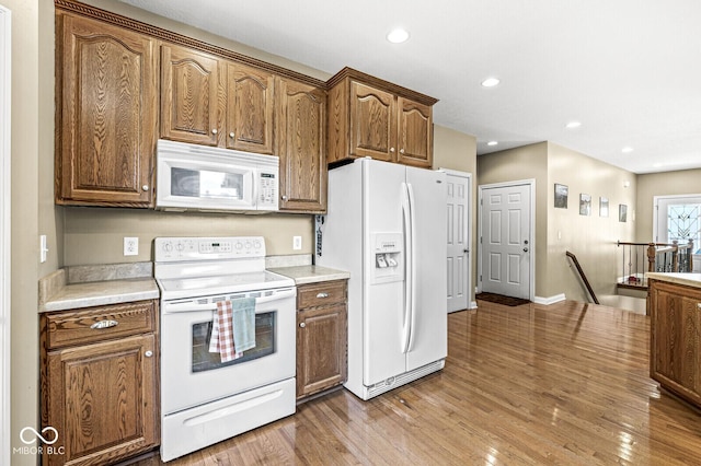 11 Stratford Way, Danville, IN 46122 - kitchen featuring white appliances, light wood-type flooring, light countertops, recessed lighting, and brown cabinetry