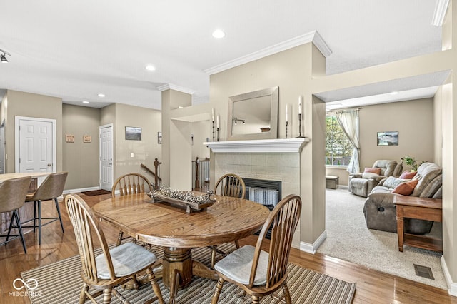 11 Stratford Way, Danville, IN 46122 - dining room featuring a tiled fireplace, wood finished floors, ornamental molding, and recessed lighting