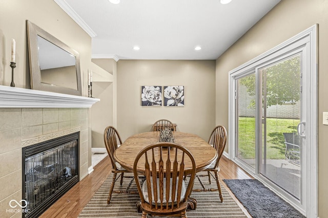 11 Stratford Way, Danville, IN 46122 - dining area featuring a tiled fireplace, wood finished floors, recessed lighting, and crown molding