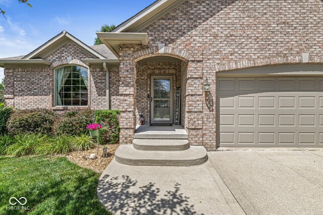 11 Stratford Way, Danville, IN 46122 - entrance to property with brick siding, a garage, a shingled roof, and driveway