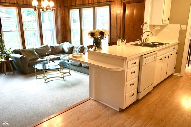 7780 Cree Trl, Indianapolis, IN 46250 - kitchen with dishwasher, light countertops, light wood-type flooring, a chandelier, and wood walls