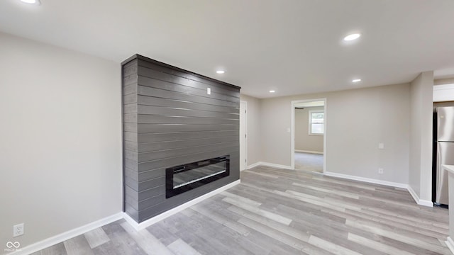 830 Stardust Blvd, Noblesville, IN 46060 - unfurnished living room with light wood finished floors, a large fireplace, and recessed lighting