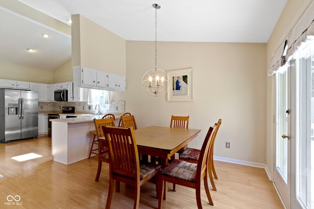 7683 Madden Dr, Fishers, IN 46038 - dining space with a chandelier, light wood finished floors, and high vaulted ceiling