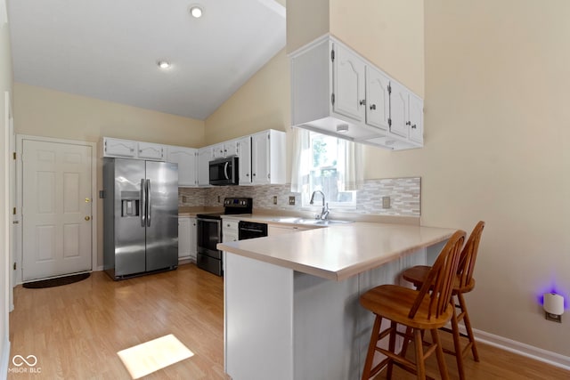 7683 Madden Dr, Fishers, IN 46038 - kitchen with stainless steel appliances, a peninsula, backsplash, light wood finished floors, and high vaulted ceiling