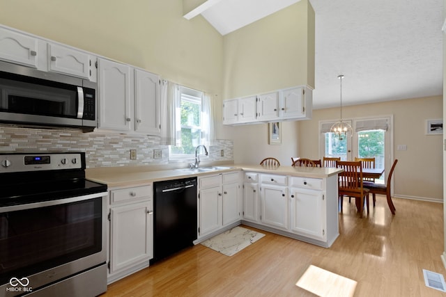 7683 Madden Dr, Fishers, IN 46038 - kitchen with appliances with stainless steel finishes, light wood-type flooring, a peninsula, white cabinets, and tasteful backsplash