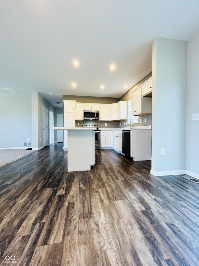 10 Doe Creek Cir, Cloverdale, IN 46120 - kitchen featuring stainless steel microwave, range with electric stovetop, dark wood finished floors, open floor plan, and recessed lighting