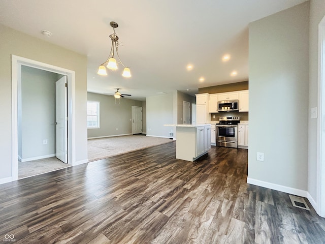 10 Doe Creek Cir, Cloverdale, IN 46120 - kitchen featuring appliances with stainless steel finishes, open floor plan, dark wood-style flooring, pendant lighting, and white cabinets