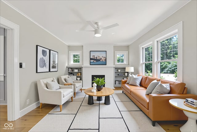 6711 Lafayette Rd, Indianapolis, IN 46278 - living area with a ceiling fan, plenty of natural light, light wood-type flooring, a large fireplace, and ornamental molding