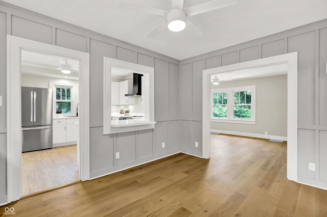 6711 Lafayette Rd, Indianapolis, IN 46278 - empty room featuring a decorative wall, ceiling fan, and light wood-type flooring