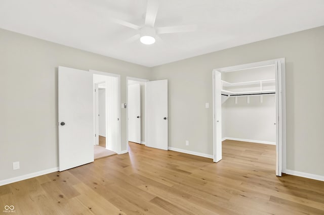 6711 Lafayette Rd, Indianapolis, IN 46278 - unfurnished bedroom with light wood-style flooring, a spacious closet, a ceiling fan, and a closet