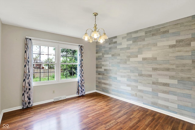 3302 Beech Dr, Columbus, IN 47203 - spare room featuring a chandelier, dark wood-type flooring, and an accent wall