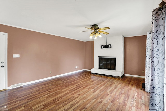 3302 Beech Dr, Columbus, IN 47203 - unfurnished living room featuring a ceiling fan, a brick fireplace, crown molding, and wood finished floors
