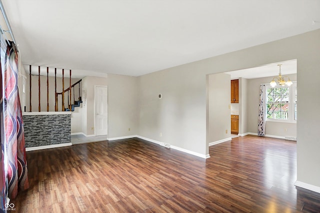 3302 Beech Dr, Columbus, IN 47203 - unfurnished living room featuring dark wood-style floors, a chandelier, and stairs