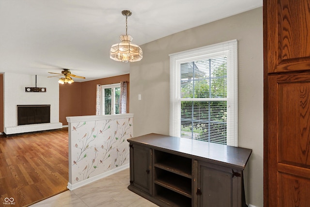 3302 Beech Dr, Columbus, IN 47203 - unfurnished dining area with ceiling fan, a chandelier, and a fireplace