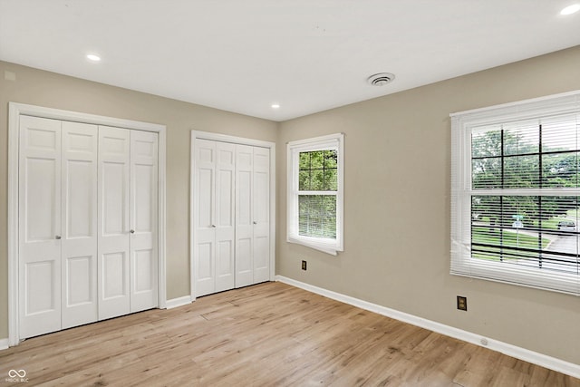 3302 Beech Dr, Columbus, IN 47203 - unfurnished bedroom featuring two closets, light wood finished floors, and recessed lighting