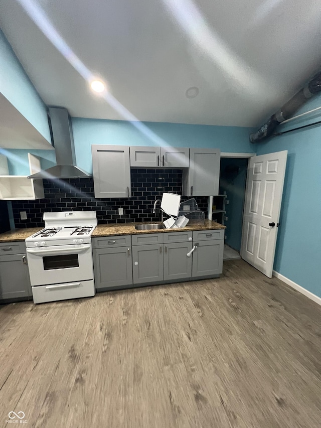 3834 N Mitthoefer Rd, Indianapolis, IN 46235 - kitchen featuring gas range gas stove, gray cabinetry, wall chimney exhaust hood, backsplash, and light wood-style floors