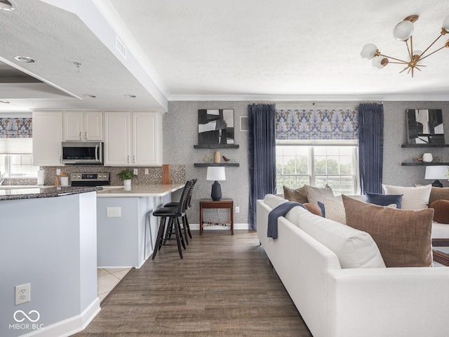 6730 Spirit Lake Dr Unit 202, Indianapolis, IN 46220 - kitchen with stainless steel appliances, open floor plan, crown molding, white cabinets, and a kitchen breakfast bar