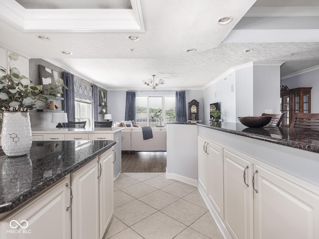6730 Spirit Lake Dr Unit 202, Indianapolis, IN 46220 - kitchen featuring ornamental molding, light tile patterned floors, white cabinetry, open floor plan, and a textured ceiling