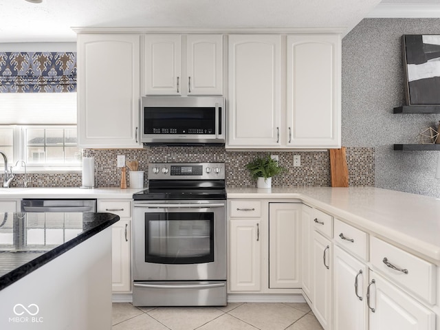 6730 Spirit Lake Dr Unit 202, Indianapolis, IN 46220 - kitchen with appliances with stainless steel finishes, white cabinetry, decorative backsplash, and light tile patterned floors