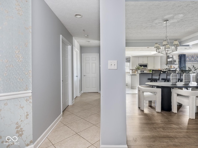 6730 Spirit Lake Dr Unit 202, Indianapolis, IN 46220 - hall featuring a chandelier, a textured ceiling, and light tile patterned floors