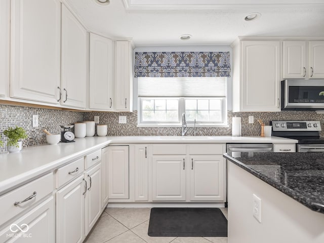 6730 Spirit Lake Dr Unit 202, Indianapolis, IN 46220 - kitchen with stainless steel appliances, white cabinets, tasteful backsplash, and light tile patterned flooring