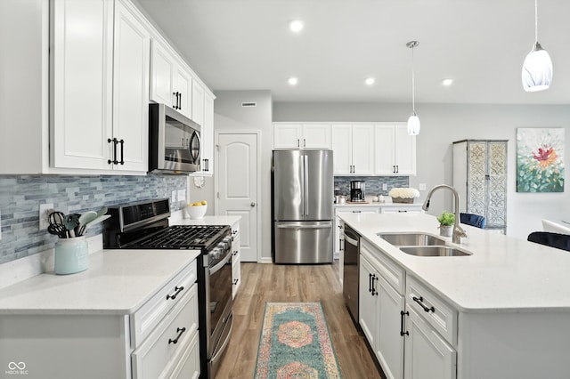 18750 Terra Vis Pl, Westfield, IN 46074 - kitchen with stainless steel appliances, wood finished floors, white cabinetry, backsplash, and recessed lighting