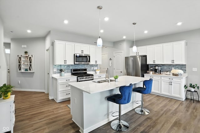 18750 Terra Vis Pl, Westfield, IN 46074 - kitchen featuring stainless steel appliances, decorative backsplash, dark wood-style flooring, a center island with sink, and light countertops