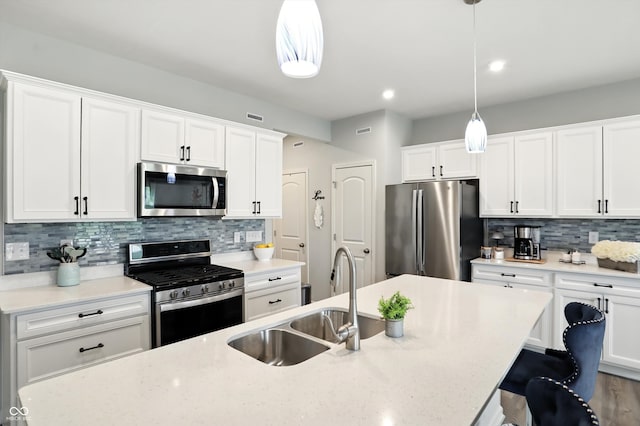 18750 Terra Vis Pl, Westfield, IN 46074 - kitchen featuring appliances with stainless steel finishes, a breakfast bar, backsplash, decorative light fixtures, and white cabinetry