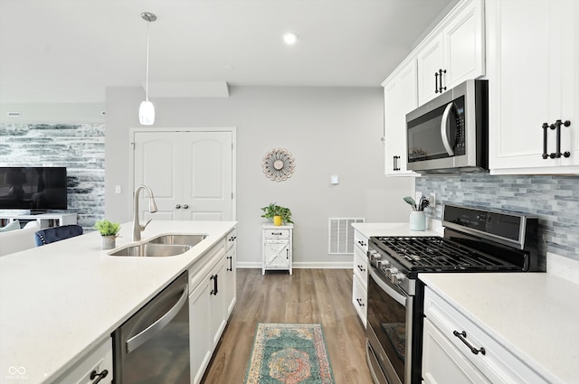 18750 Terra Vis Pl, Westfield, IN 46074 - kitchen with stainless steel appliances, light countertops, light wood-style flooring, tasteful backsplash, and white cabinetry