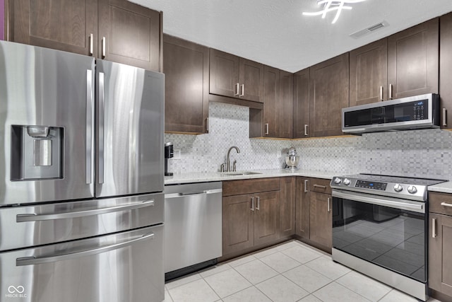 8650 Jaffa Ct W Drive 32, Indianapolis, IN 46260 - kitchen with stainless steel appliances, light tile patterned floors, dark brown cabinets, and tasteful backsplash