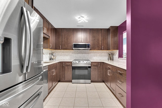 8650 Jaffa Ct W Drive 32, Indianapolis, IN 46260 - kitchen with stainless steel appliances, light countertops, backsplash, and light tile patterned flooring