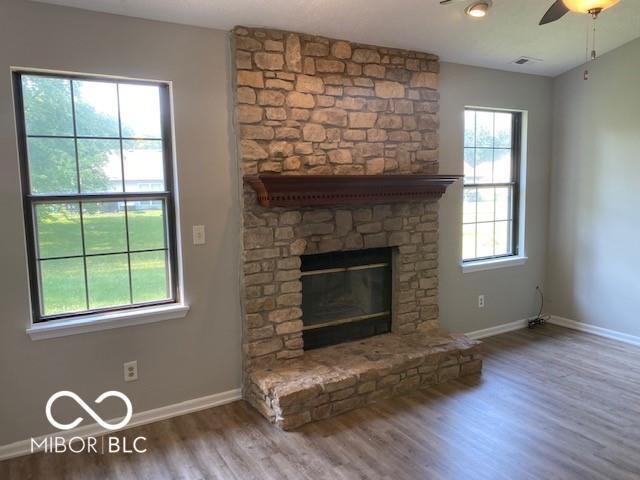 7313 Shanna Cir, Indianapolis, IN 46236 - unfurnished living room with wood finished floors, ceiling fan, and a fireplace