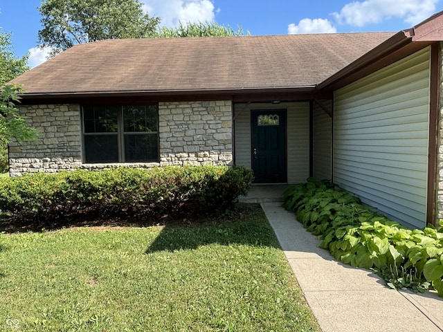 7313 Shanna Cir, Indianapolis, IN 46236 - view of exterior entry with stone siding, a lawn, and a shingled roof