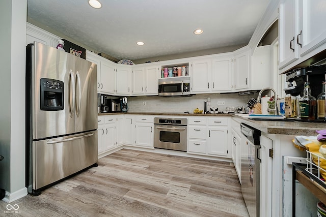 1616 Beech Cir, Plainfield, IN 46168 - kitchen featuring stainless steel appliances, white cabinetry, light wood-style flooring, recessed lighting, and backsplash