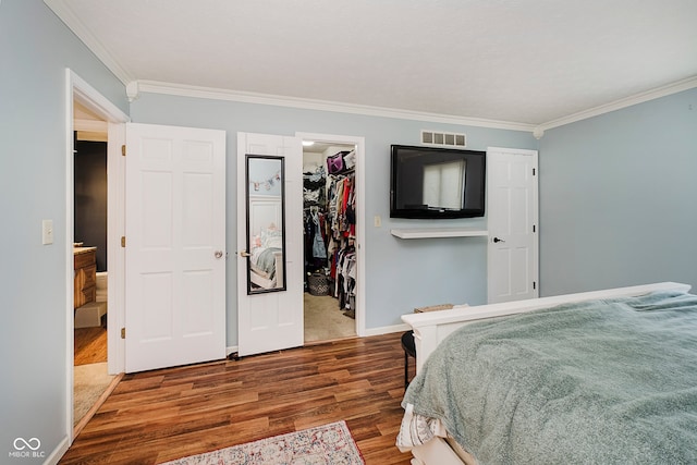 1616 Beech Cir, Plainfield, IN 46168 - bedroom with wood finished floors, crown molding, a walk in closet, and a closet