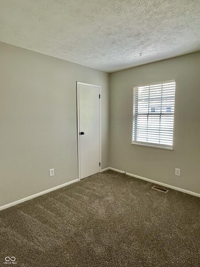 4933 Oakwood Trl, Indianapolis, IN 46268 - empty room with dark carpet and a textured ceiling