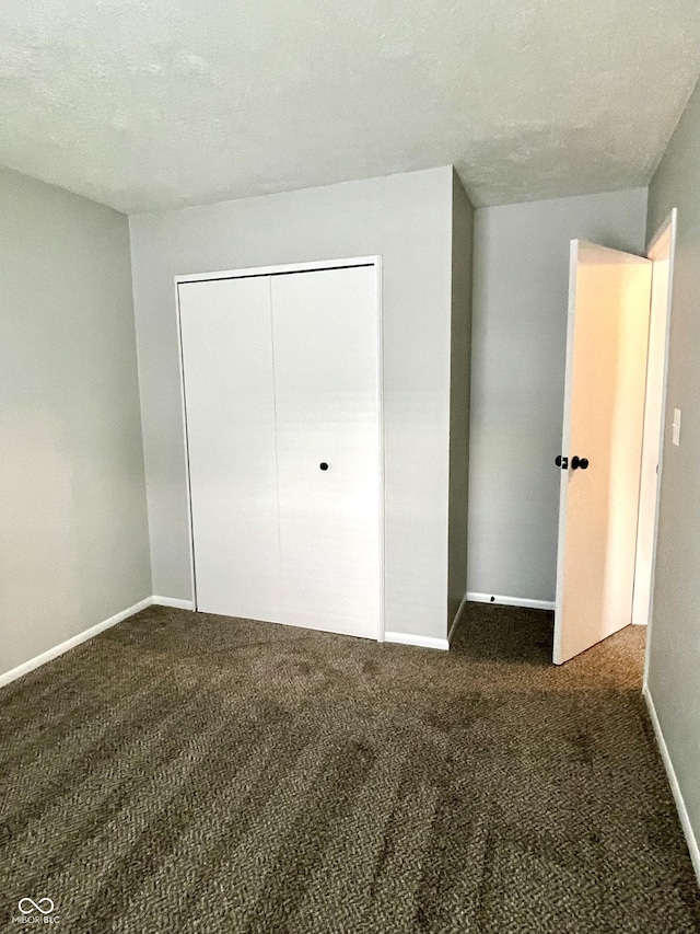 4933 Oakwood Trl, Indianapolis, IN 46268 - unfurnished bedroom featuring dark carpet and a closet