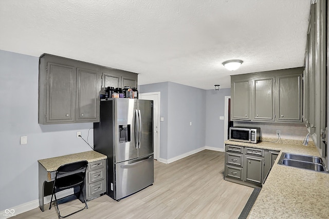 125 E Waterbury Rd, Indianapolis, IN 46227 - kitchen with stainless steel appliances, light countertops, light wood finished floors, decorative backsplash, and a textured ceiling