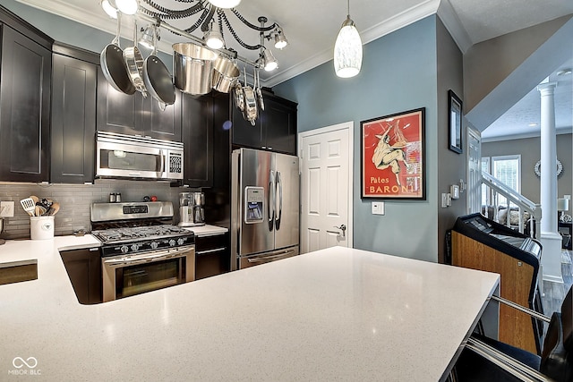 1551 N Park Ave, Indianapolis, IN 46202 - kitchen featuring stainless steel appliances, ornamental molding, ornate columns, tasteful backsplash, and dark cabinetry