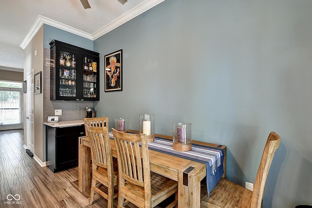 1551 N Park Ave, Indianapolis, IN 46202 - dining room featuring crown molding, a bar, and light wood finished floors
