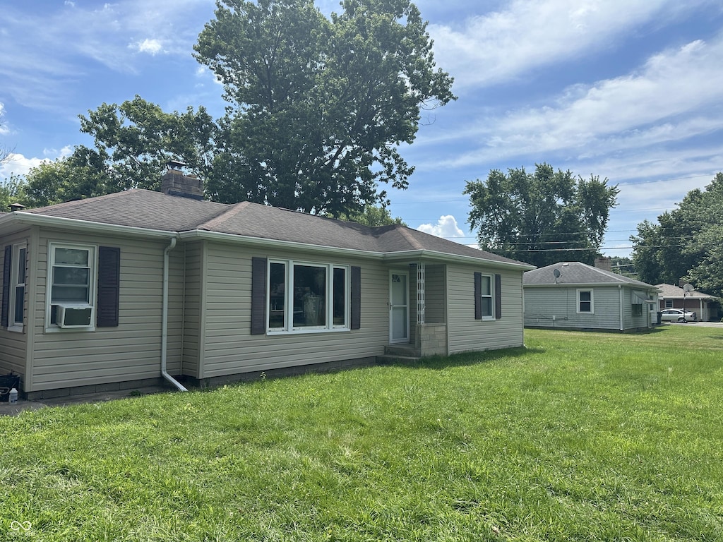 497 S Hendricks Dr, Greenwood, IN 46142 - ranch-style house featuring a front yard, a chimney, cooling unit, and a shingled roof