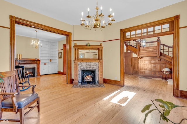 408 E Wabash Ave, Crawfordsville, IN 47933 - living room featuring a fireplace, a chandelier, hardwood / wood-style floors, and stairs