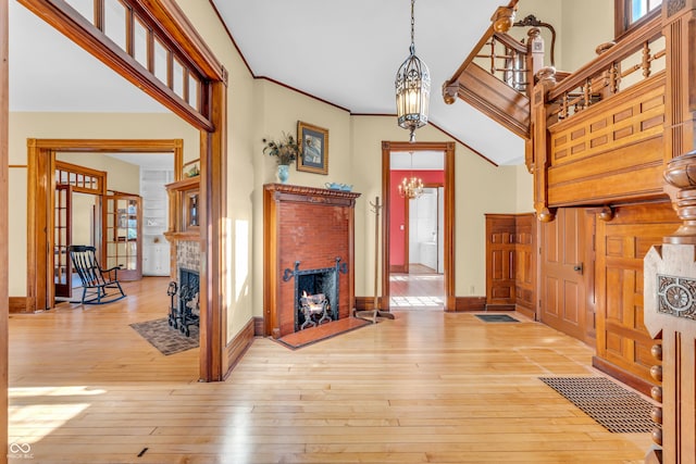 408 E Wabash Ave, Crawfordsville, IN 47933 - foyer entrance featuring a fireplace, light wood-style flooring, and a chandelier