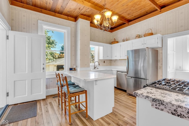 408 E Wabash Ave, Crawfordsville, IN 47933 - kitchen with appliances with stainless steel finishes, wallpapered walls, a wooden ceiling with exposed beams, light wood finished floors, and a chandelier